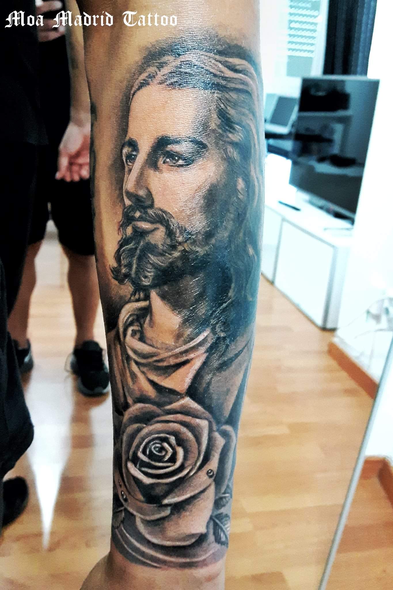 Realista retrato de Cristo en el antebrazo con una rosa