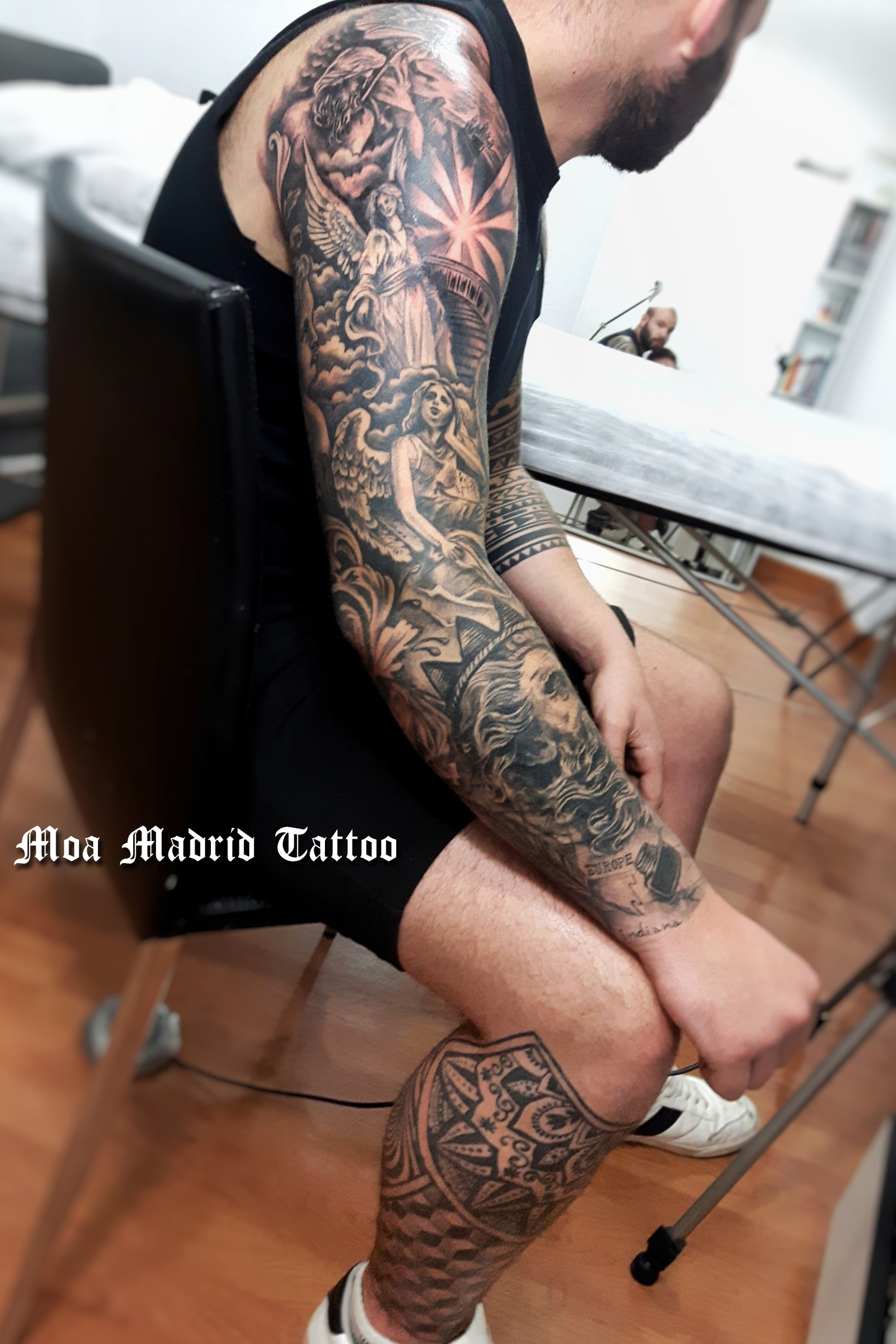 Brazo completo con más de una docena de tatuajes de grupos escultóricos y motivos arquitectónicos