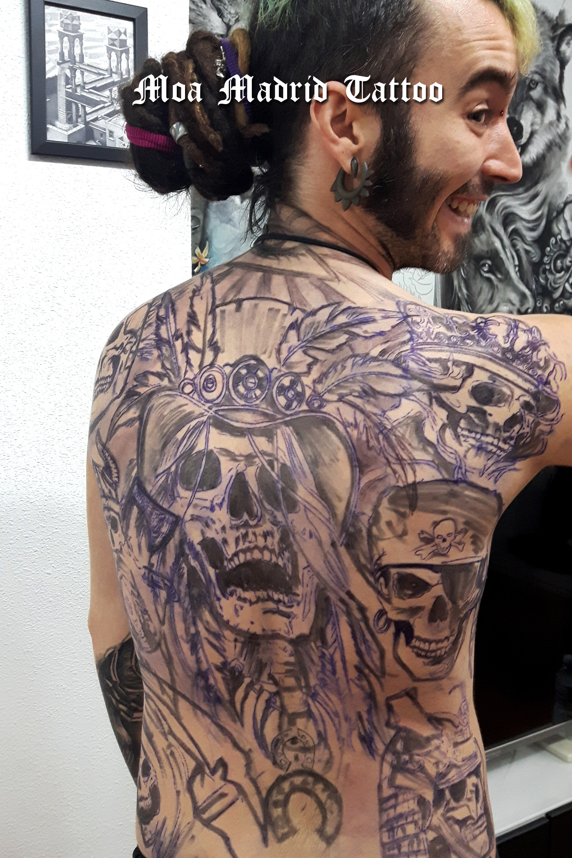 Espalda entera tatuada con calaveras