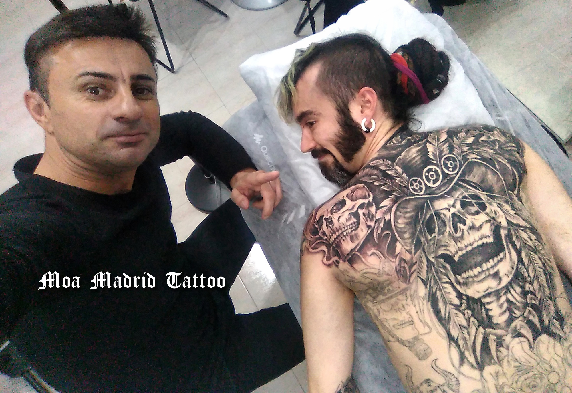 Espalda entera tatuada con calaveras