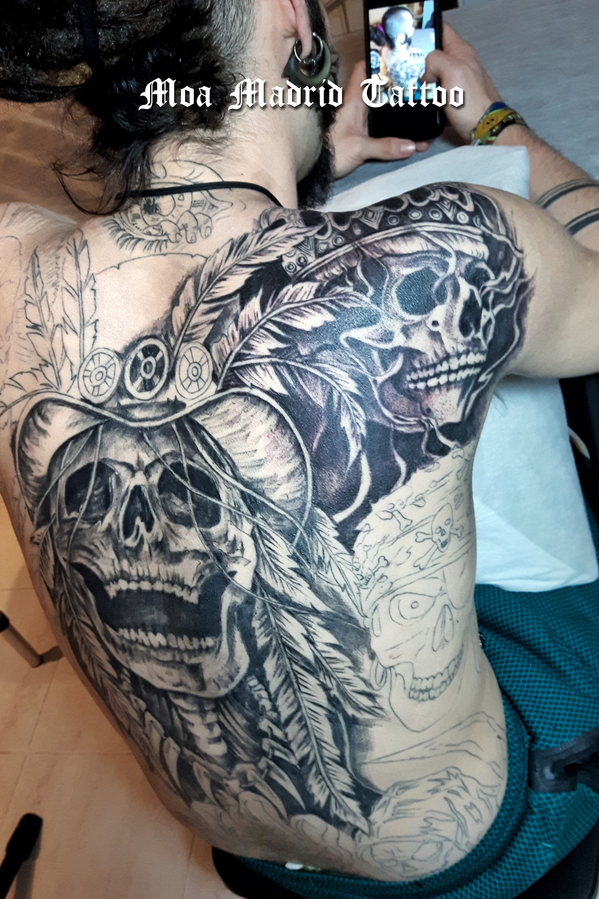 Espalda entera tatuada con calaveras