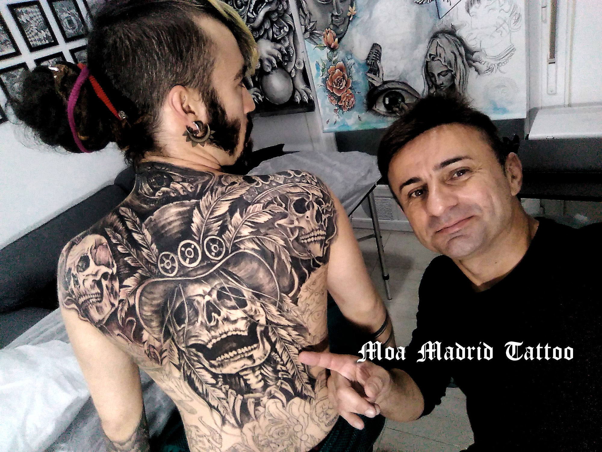 Espalda entera tatuada con calaveras