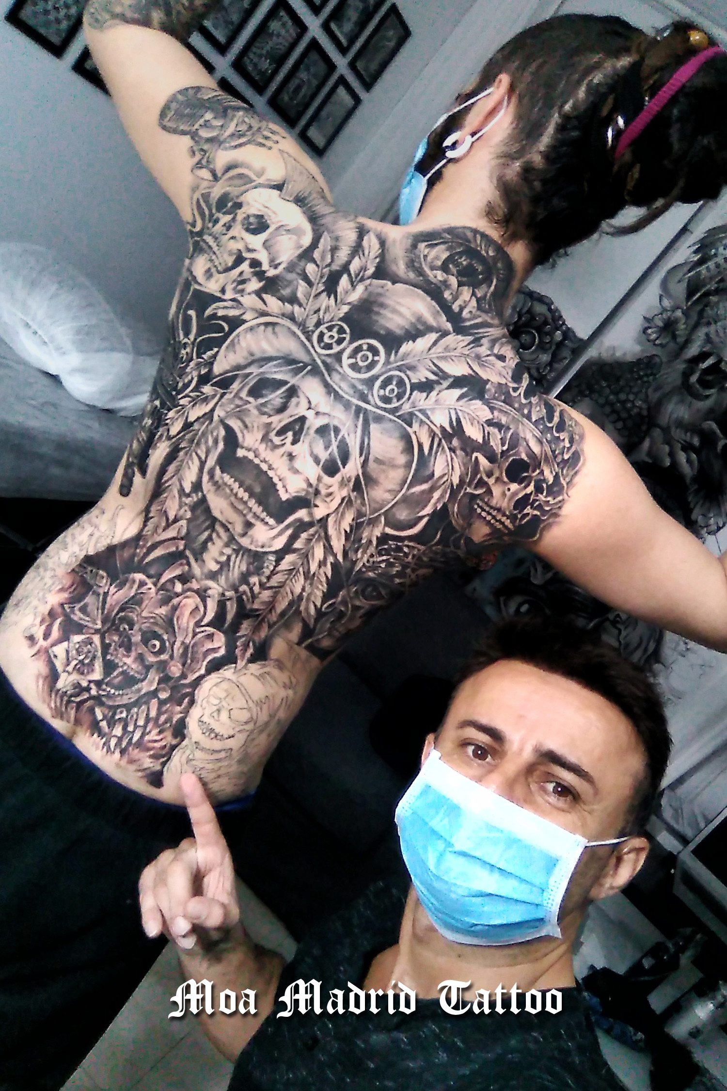 Espalda entera tatuada con calaveras