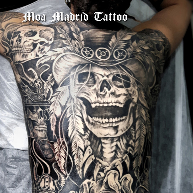 Espalda entera tatuada con calaveras