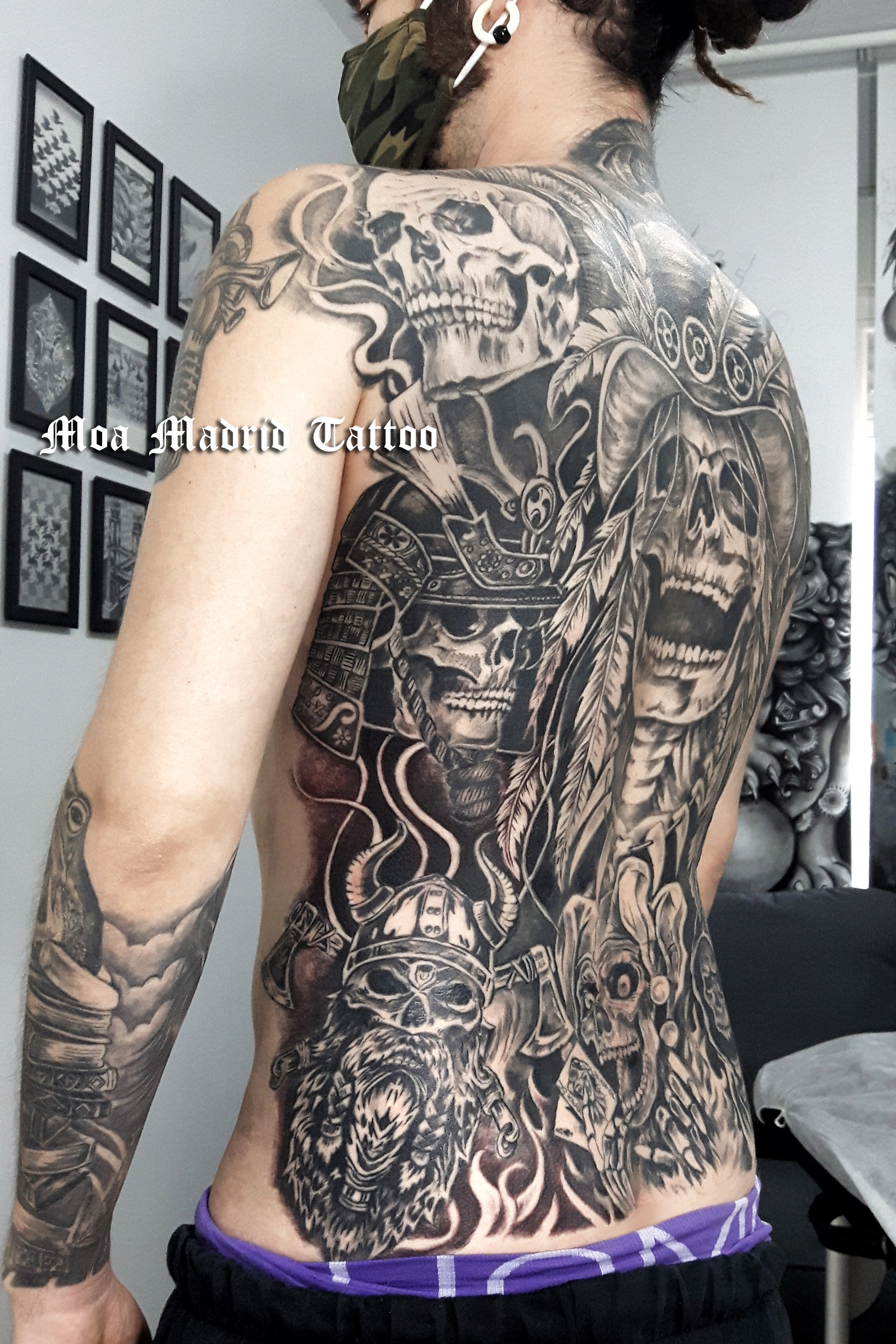 Espalda entera tatuada con calaveras