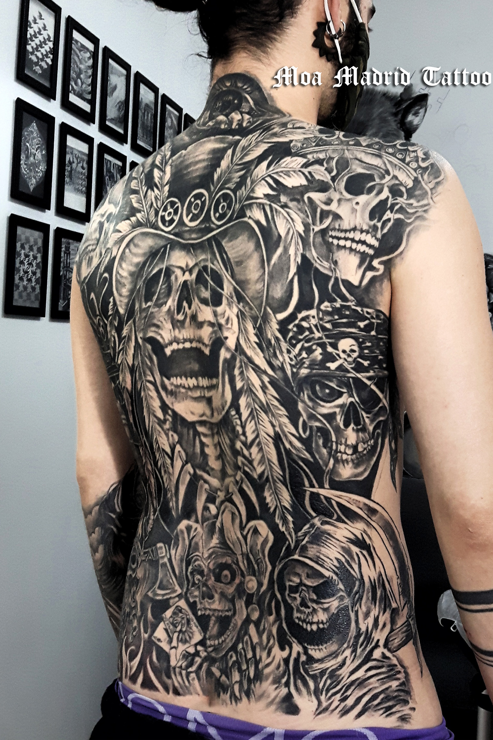 Espalda entera tatuada con calaveras
