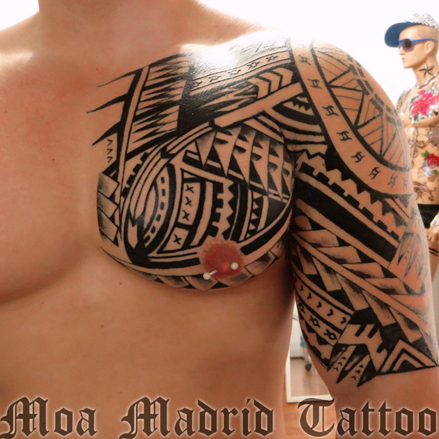 Tatuaje maorí en pectoral, hombro y brazo