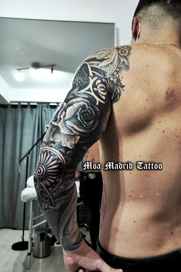 Brazo entero con tatuajes realistas