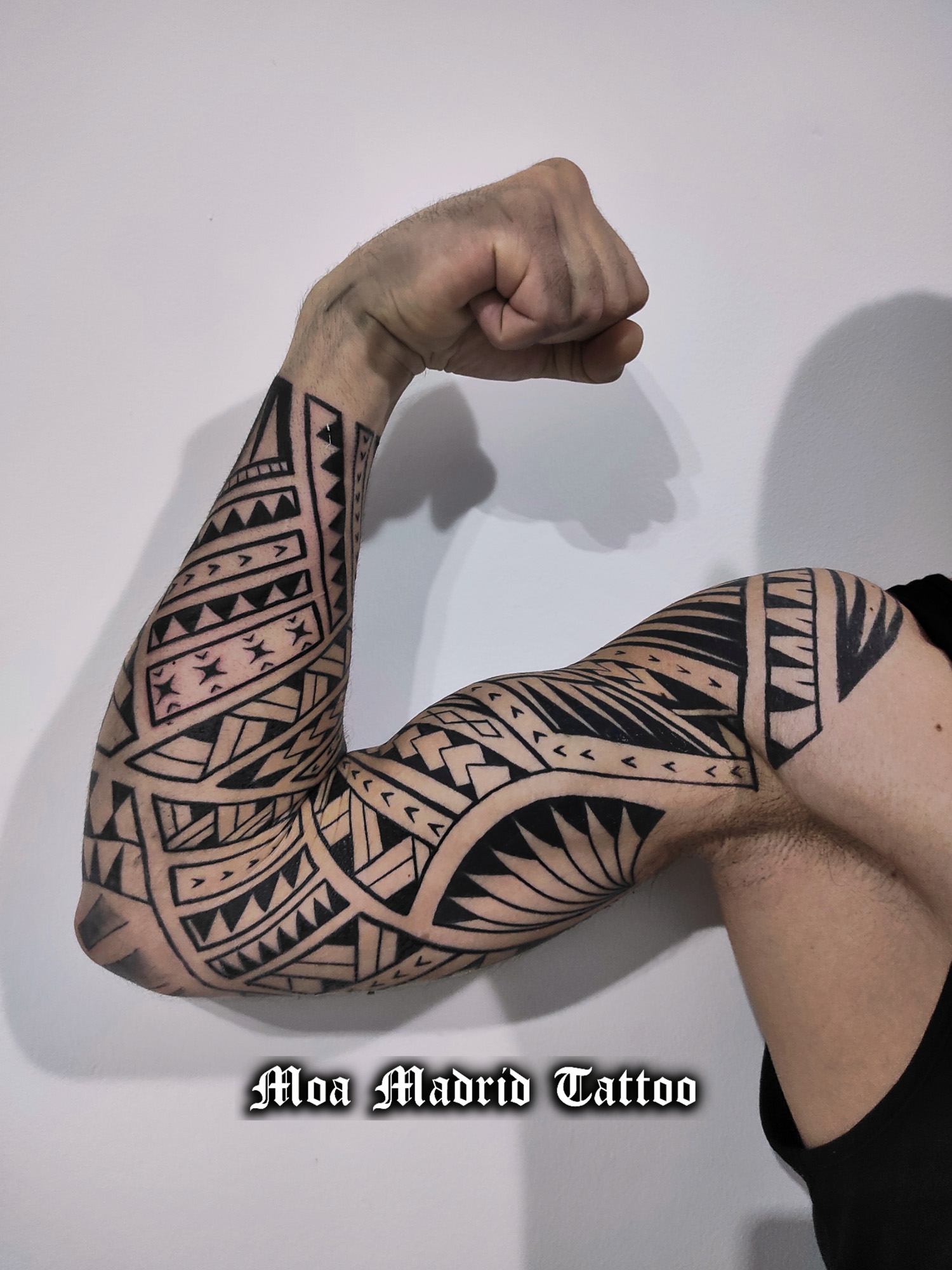 Diseño de tatuaje samoano siguiendo los músculos del brazo