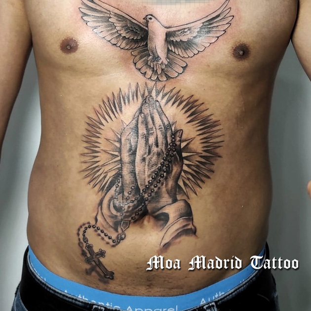 Tatuajes de manos orando con rosario y paloma en abdomen y pecho