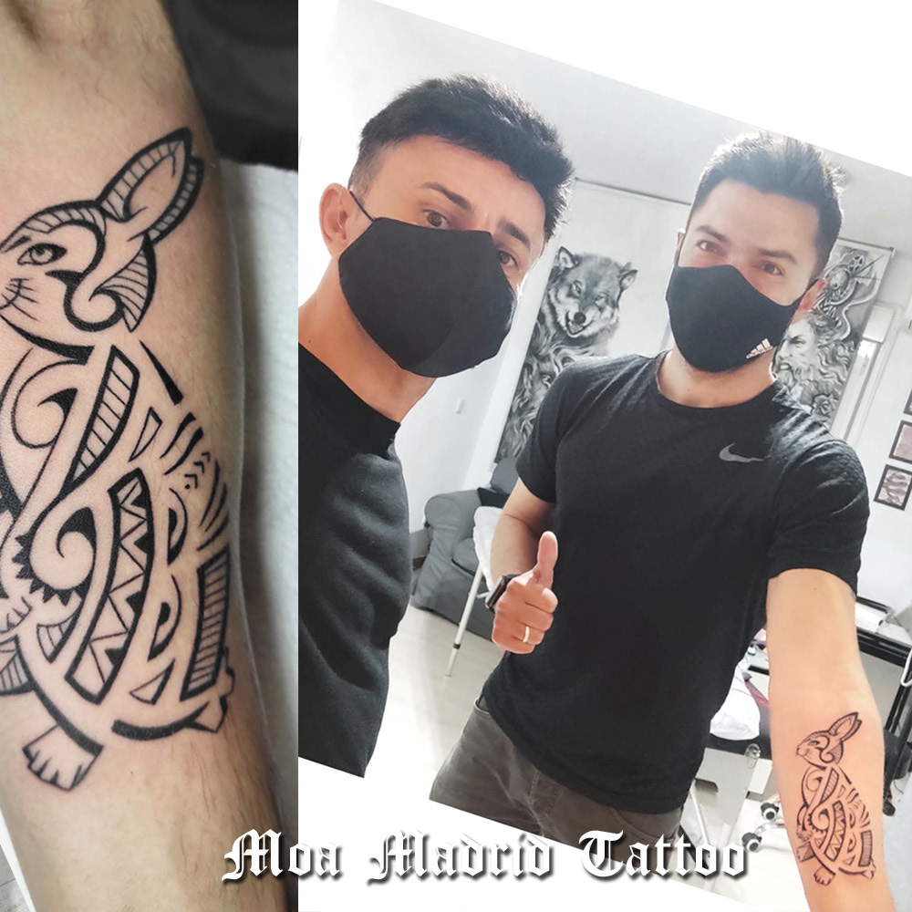 Tatuaje estilo maorí de conejo en el antebrazo elegido entre varios diseños