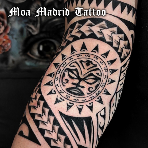 Tatuaje maorí con sol rodeando el codo