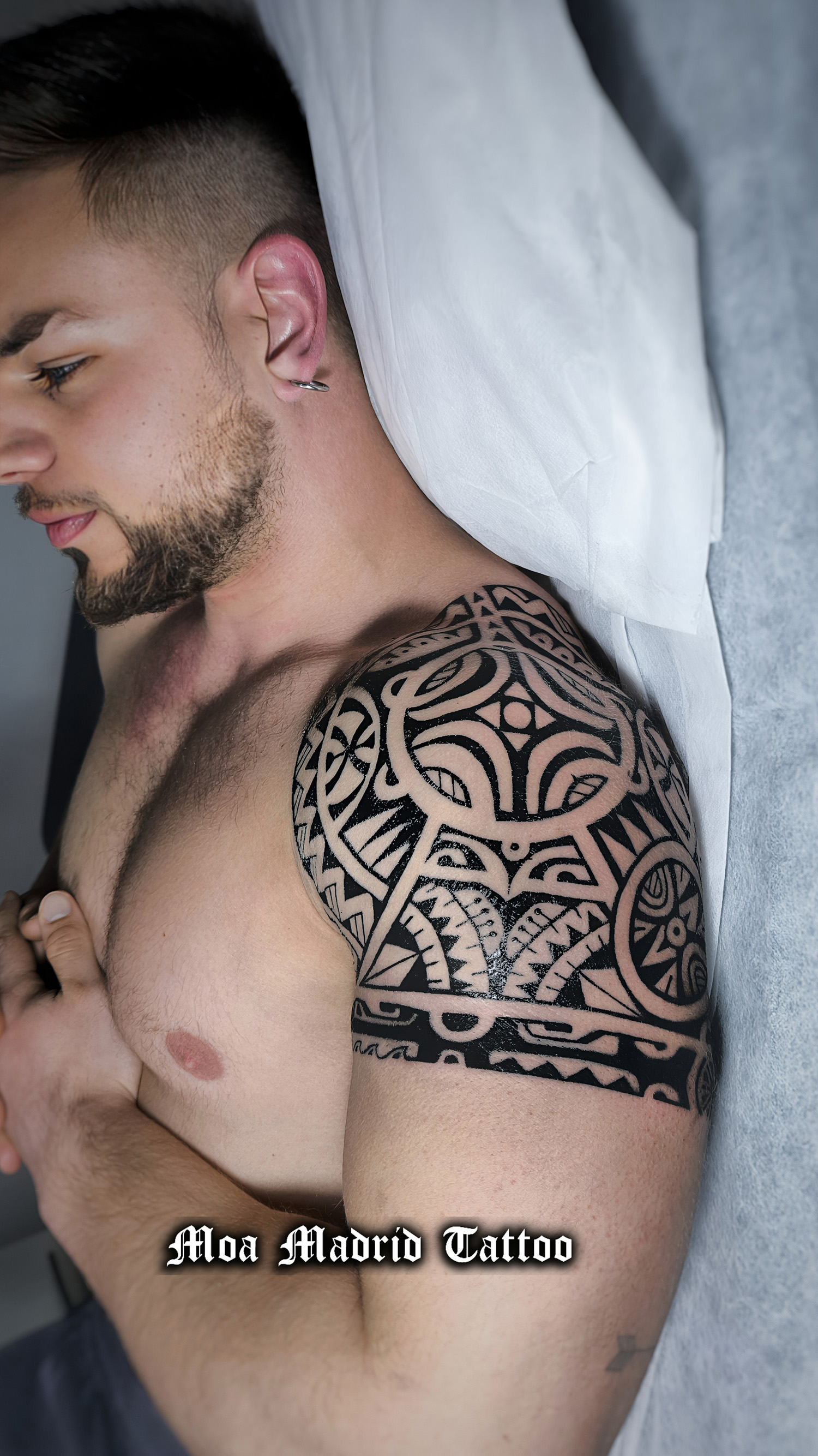 Diseño de tatuaje en la parte superior del brazo, con cruz marquesana y símbolos polinesios Gaby del Castillo