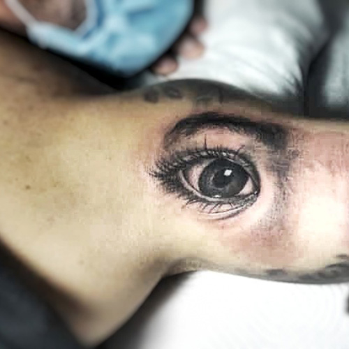 Tatuaje de ojos muy realistas en el tríceps